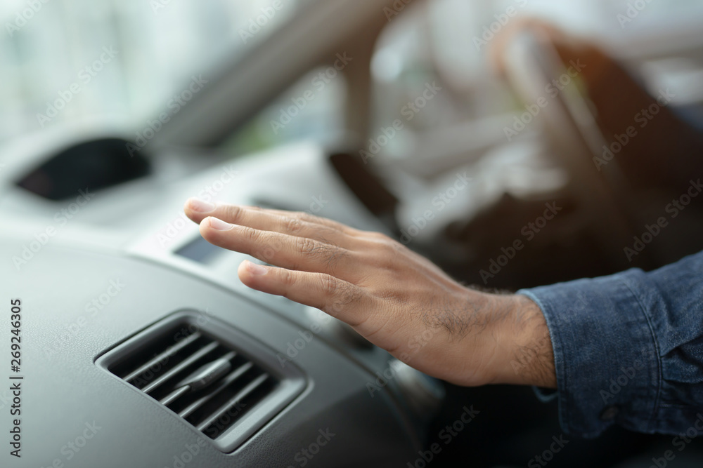 Closeup of hand driver man checking adjusting air from conditioning the cooling system with flow of cold air in car. Leave space for writing text. Closeup of hand driver man checking adjusting air from conditioning the cooling system with flow of cold air in car. Leave space for writing text.