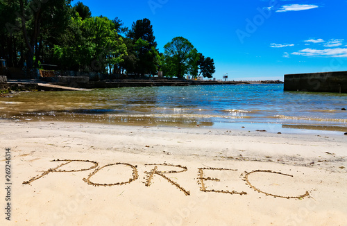 Fototapeta Naklejka Na Ścianę i Meble -  Porec, the name of the town in Croatia, written in sand on the beach in Porec