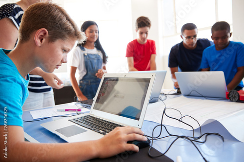 Group Of Students In After School Computer Coding Class Learning To Program Robot Vehicle