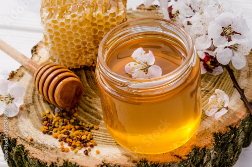 Natural honey products from fresh flower sweet honey in a glass jar, honeycombs, bee pollen