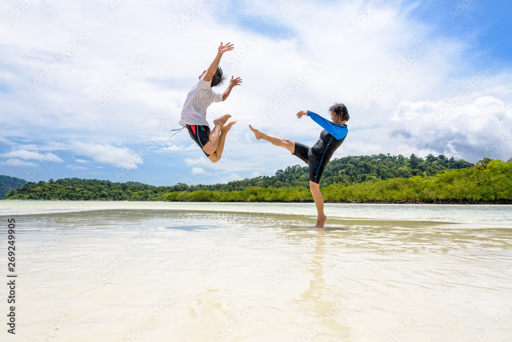 Couple play fun woman show kicking a man on the beach