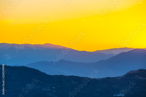mountain ridge silhouette in a blue mist at the sunset, natural background