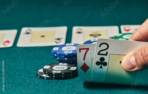 Foto Bad poker gamble or unlucky hand concept with player going all in with 2 and 7 (