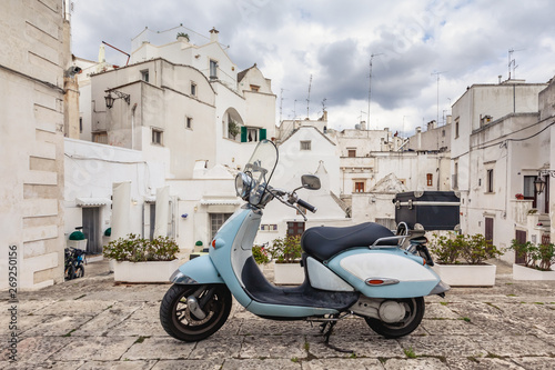 View of the old town of Martina Franca. Classic blue moped on the background of an anient buildings.