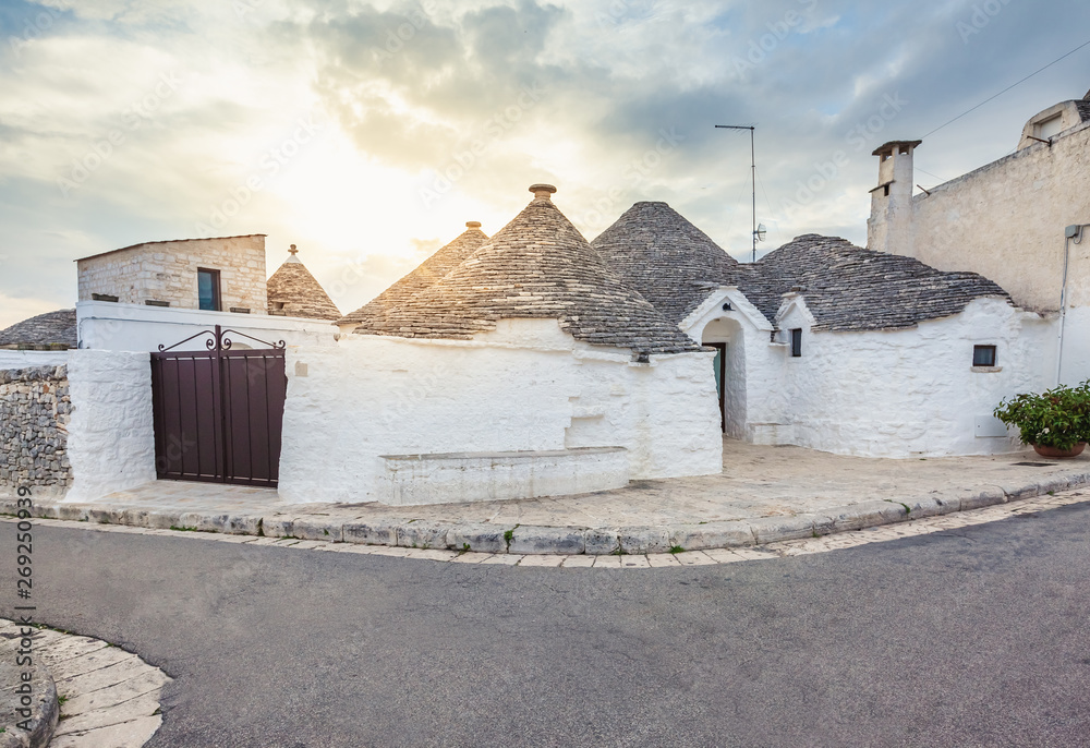 Beautiful town of Alberobello with Trulli houses among green plants and flowers, Apulia region, Southern Italy.