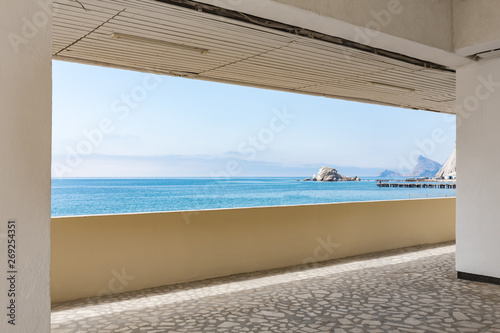 Calm blue sea with distant mountains seen from the seafront resort promenade  beautiful marine scenery