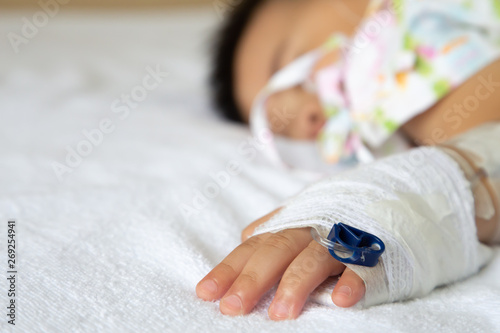 Asian baby boy sleeping on bed with infusion set at child department in the hospital. Children with infectious diseases IPD, Invasive Pneumococcal Disease concept. Infant model one year six months