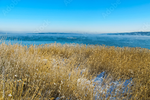 Fototapeta Naklejka Na Ścianę i Meble -  view over the reeds and the misty ammersee to Herrsching, a hiding place for spawning fish in the lake