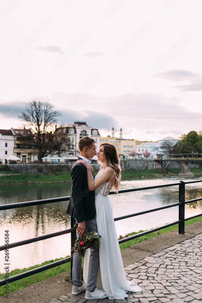 loving couple on the river bank in Europe. Hugging and kissing