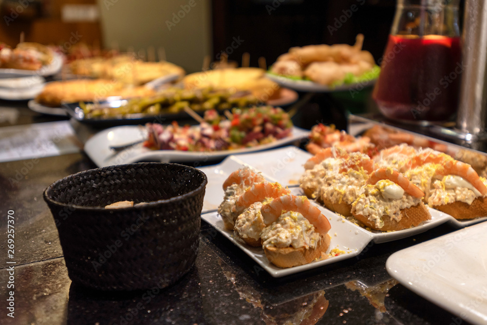 Obraz premium Porcje różnych pintxos lub tapas w barze w San Sebastian w Hiszpanii