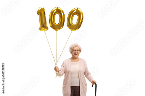 Old woman with a golden number hundred balloon and a walking cane photo