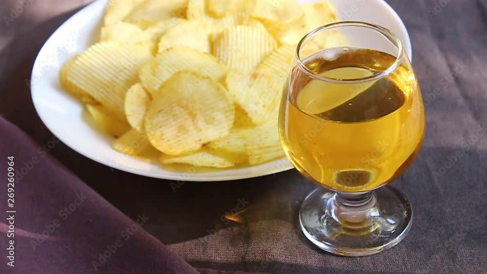potato chips and drink on a dark background. The sun's rays are reflected on the table. cafe or restaurant potato chips and drink on a dark background. The sun's rays are reflected on the table. cafe or restaurant