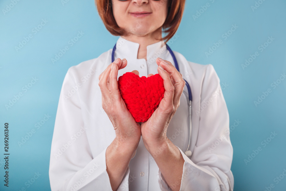 Medicine doctor holding red heart shape in hand Medicine doctor holding red heart shape in hand