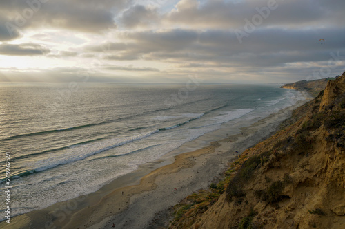 Aerial view of pacific coastline with yellow sandstone cliffs and waves rushing the beach during sunset. Black Beach  Torrey Pines State Natural Reserve  San Diego  California  USA