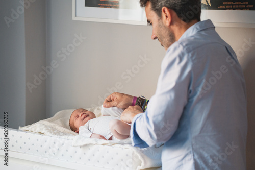 Принти на полотні New father changing the diaper to his cute newborn