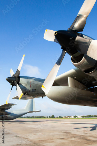 Military transport aircraft on runway at an airport.