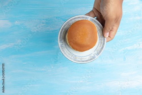 hand holding plate with dorayaki (Japanese Pancake Sandwich)