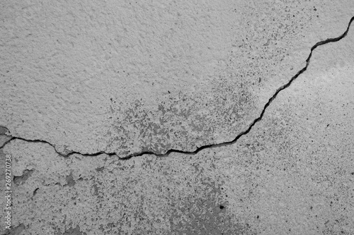 Graue Steinwand, Betonwand mit einem tiefen Riss durch die Bildmitte. Alte abgenutzte Wand mit abgerieben Strukturen und poröser Oberfläche. Hintergrund, Textur Element, Kratives Motiv für Kunst.