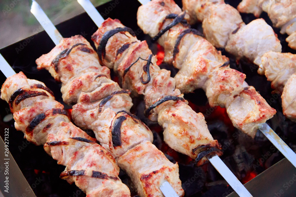 Skewers on skewers on the grill. Grilled meat on the coals. Marinated meat.