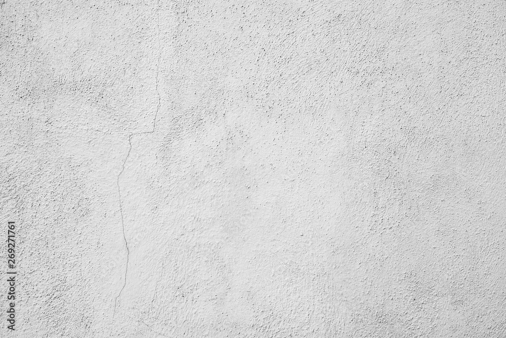 Obraz premium Hellgrauer Hintergrund, Industrial Design. Verputzte Mauer mit einem Riss in der linken Bildhälfte, Raue Struktur und leichte Verschmutzungen. Texturierte Steinwand als gestalterisches Element.