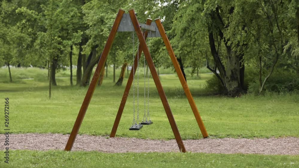 Empty playground after rain. Swing got wet in raindrops. Summer or spring rainy day. No people. No children. Empty playground after rain. Swing got wet in raindrops. Summer or spring rainy day. No people. No children.