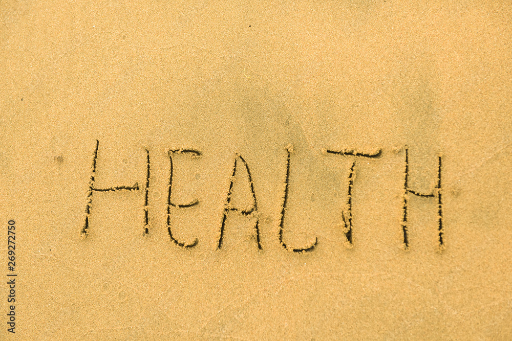 Fototapeta premium Word Health written on sand beach in the summer on vacation inspire to travel. Romantic travel for love couples or family. Sun tan cream or lotion with spf to prevent skin cancer or melanoma or burn