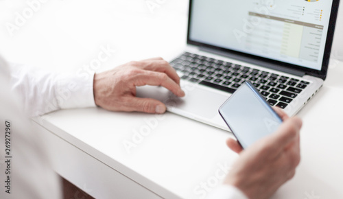 businessman using a laptop and his smartphone