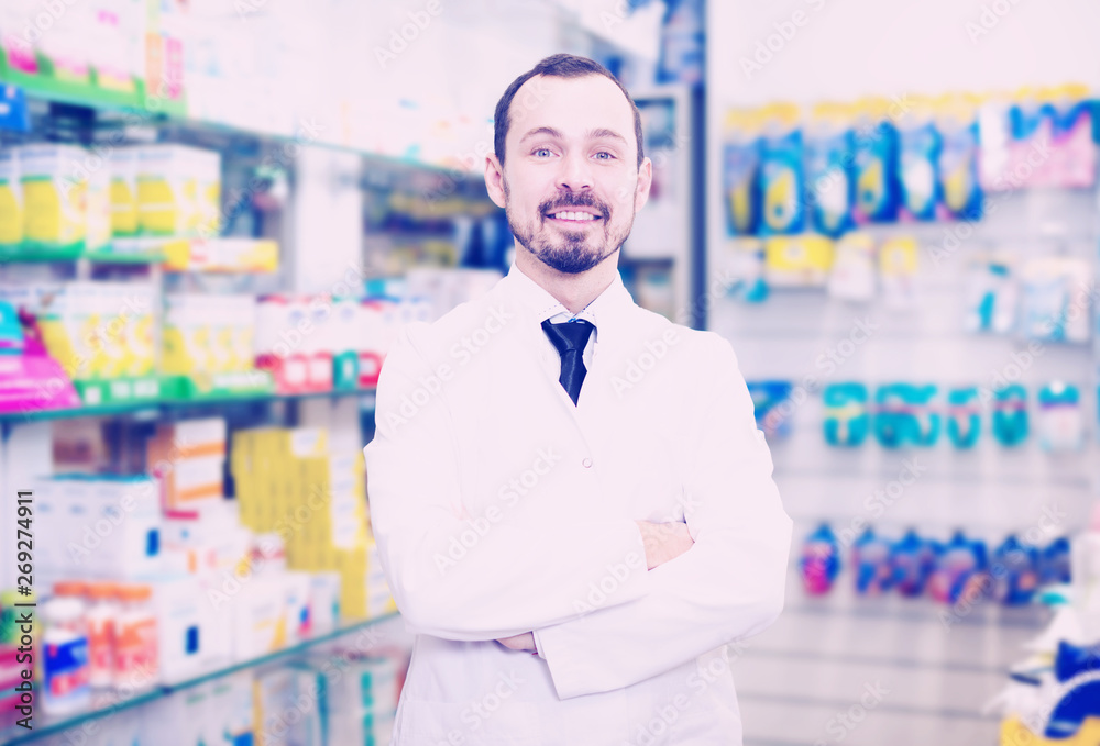 Male pharmacist displaying assortment of drugs