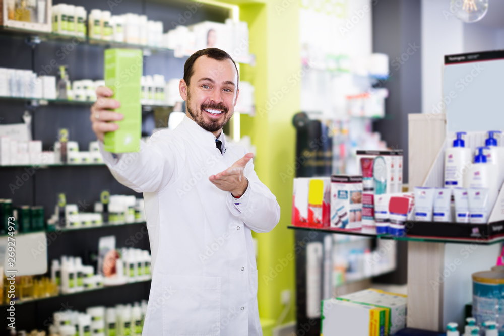Positive man pharmacist showing right drug