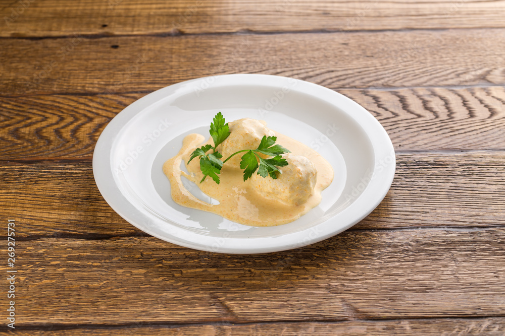 Fish meatball with white sauce isolated on wooden background Fish meatball with white sauce isolated on wooden background