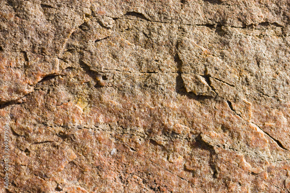 Background of granite. Texture of granite stone. Pattern of roughened surface. Texture of brown stone