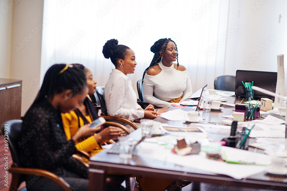 African american women colleagues, crew of divercity female partners in office sit at the table. African american women colleagues, crew of divercity female partners in office sit at the table.