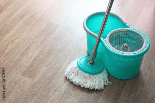 Home wet cleaning concept background. Bucket with a mop on a floor.