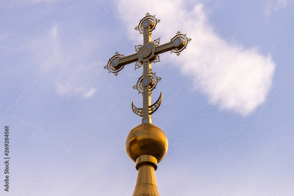 Golden dome with a cross against the sky. Orthodox cross in the blue sky. Christianity. Religion. Orthodox Christianity. Jesus. Easter.