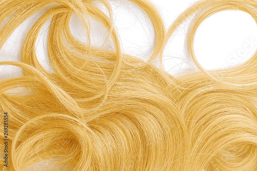 Curly blond hair as background, texture. One of the popular shades of hair coloring..