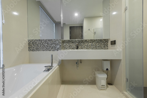 Condo bathroom design with single vanity cabinet and grey tiles on the walls.