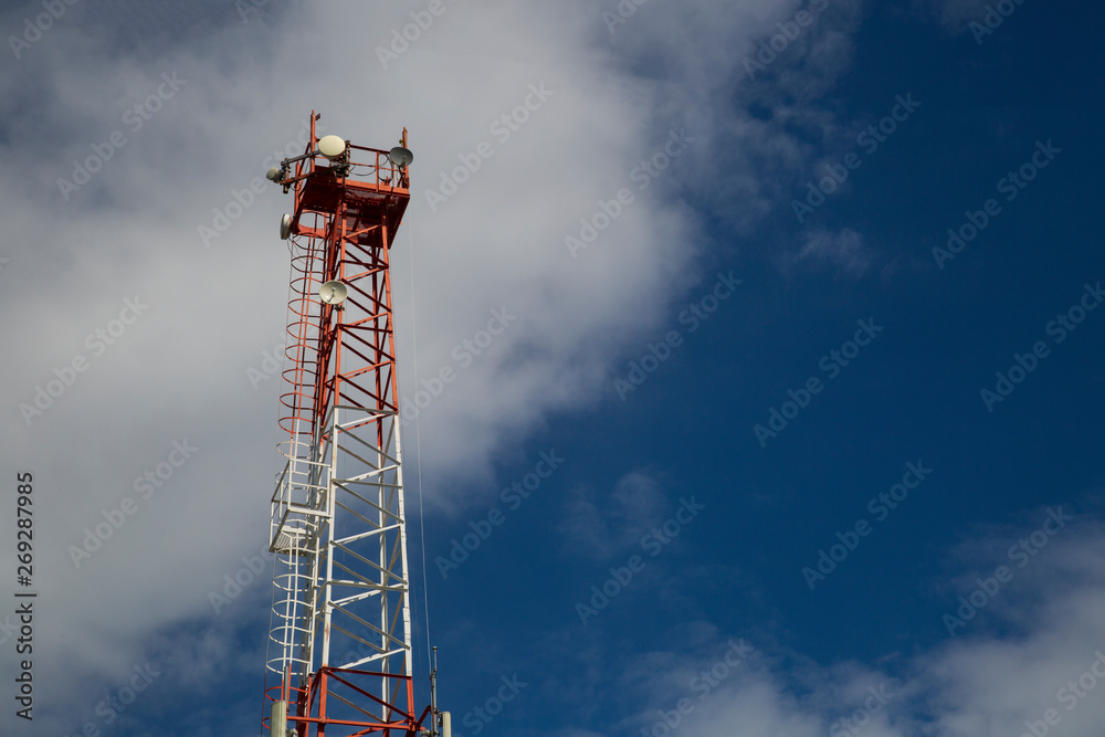 Cell phone antenna tower in a blue sky with clouds. Cell phone antenna tower in a blue sky with clouds.
