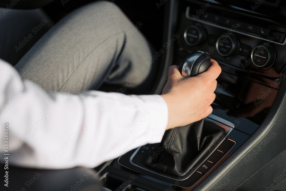 Woman`s hand on the automatic transmission's close-up.