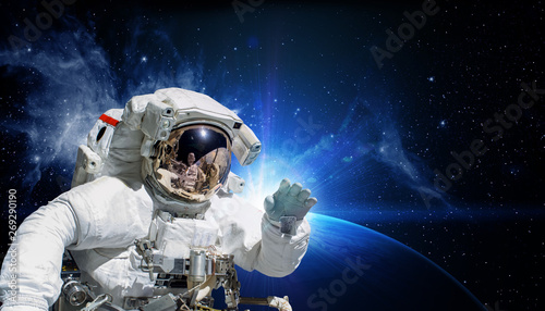 Astronaut in space suit in the space with the sunrise on Earth. Elements of this image furnished by NASA.ce