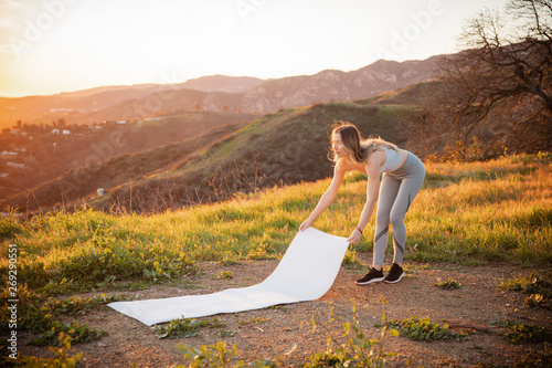 Εκτύπωση καμβά Full length of sportswoman holding exercise mat on mountain during sunset