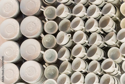 White coffee cups in rows on table. Cup prepared for hot drink such as coffee or tea in local coffee cafe or restaurant