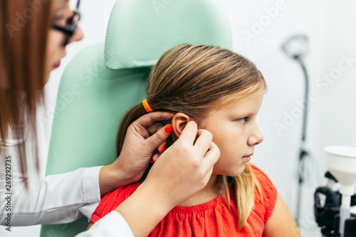 Young girl at medical examination or hearing aid checkup in otolaryngologist s office