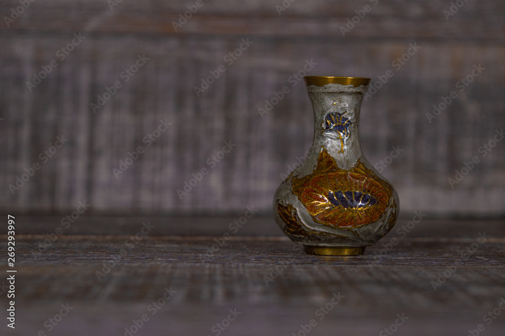 Artistic ancient pottery vase isolated on a dark grey background used for decoration.