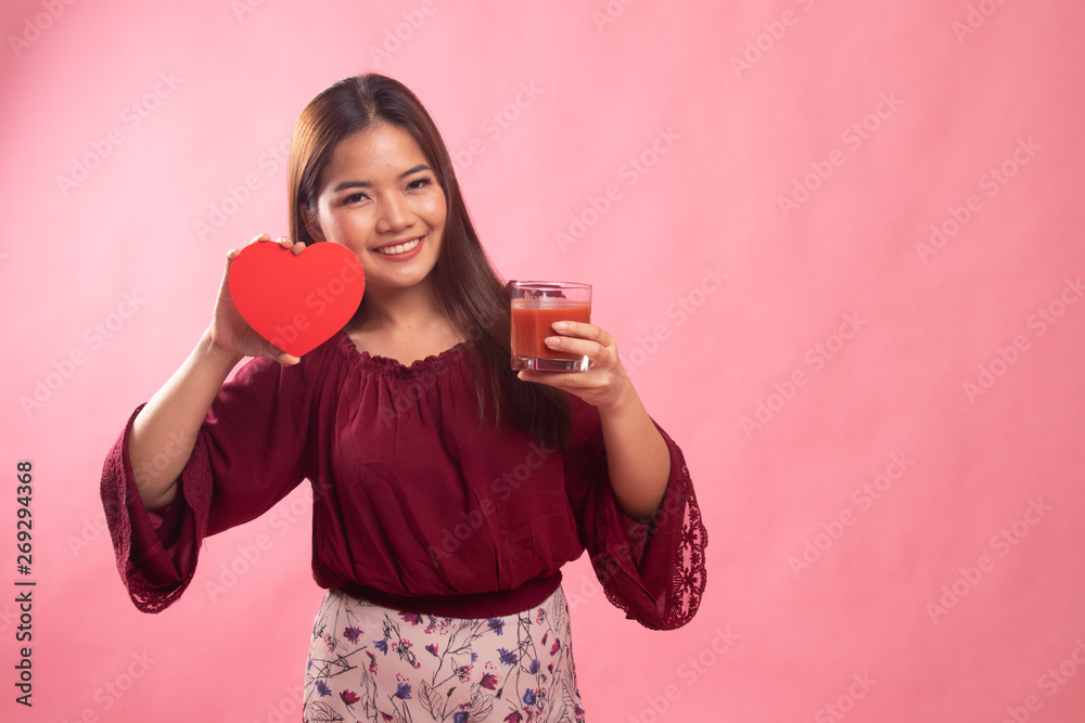 Young Asian woman with tomato juice and red heart. Young Asian woman with tomato juice and red heart.