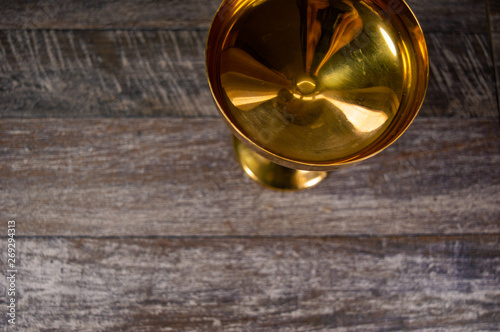 Vintage gold antique cup on a dark grey background used as decoration.