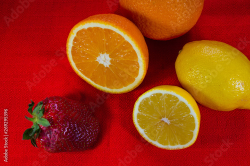 Juicy fresh slices of fruit strawberries lemons and oranges on a table.