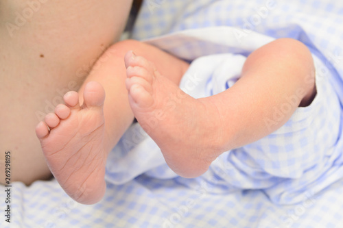 Newborn baby feet in blue nappy.