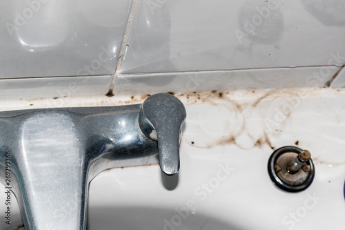 Bathroom dirt and mould on grouting and tiles behind taps