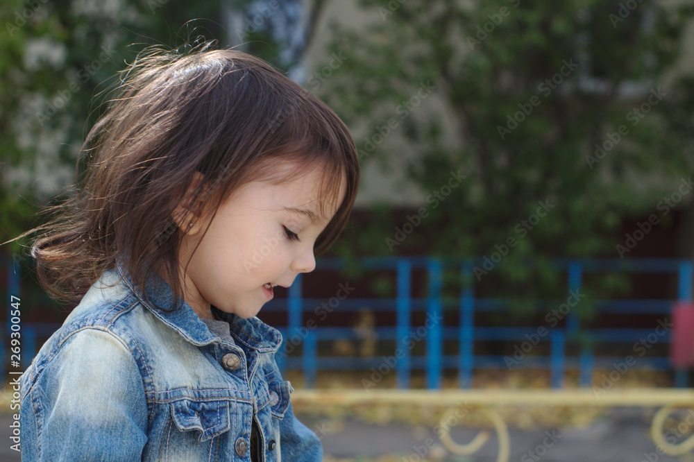 Naklejka premium closeup portrait of little cute emotional girl with pigtails in a denim jacket