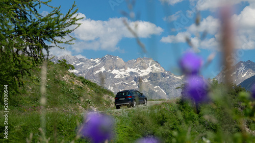 CLOSE UP: SUV drives along the scenic road in the beautiful French mountains. © helivideo